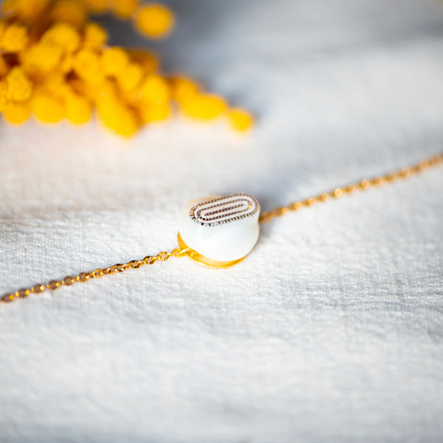 Assuna – Bracelet chaîne simple Georgette blanc et or – bouton ancien 1940